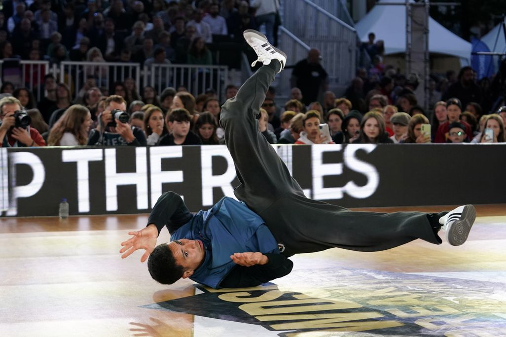 A man dancing on the ground in front of an audience