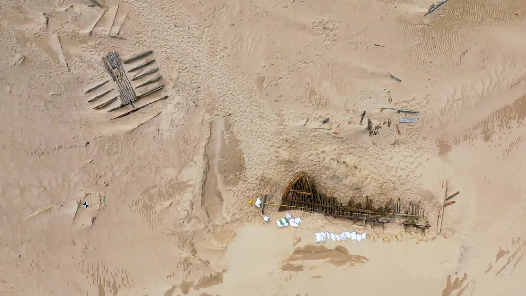 Overhead view of sand with some wooden artifacts visible