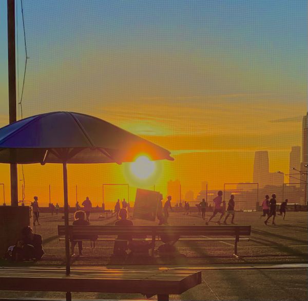 A game of soccer in Brooklyn at the piers, looking west toward lower Manhattan and the sunset. thumbnail