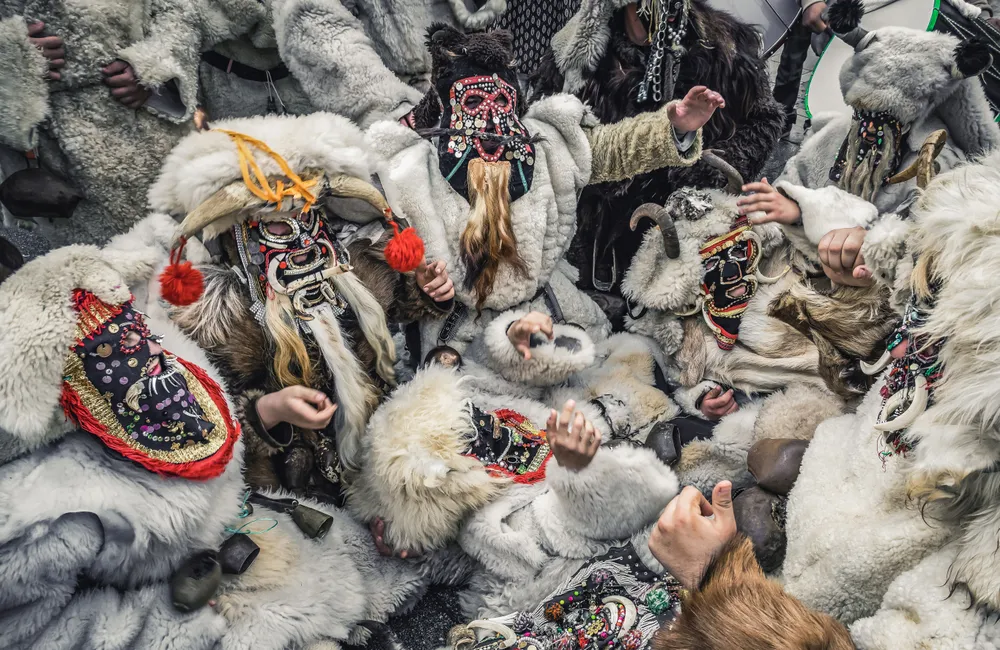 This photo shows a lively scene from the Carnival of Prochka in Macedonia, a celebration of forgiveness and renewal. The people in the image are dressed in thick fur costumes and wearing colorful, handcrafted masks decorated with beads, sequins, and tassels. Their masks, some with horns and animalistic features, seem to represent creatures from ancient folklore, blending human and wild elements.

The carnival is held on Forgiveness Sunday, a day when people come together to forgive each other and let go of past grievances before the start of Lent. In this moment, the participants appear to be caught up in a traditional dance or ritual, symbolizing transformation and a fresh start. It's a blend of old customs and vibrant energy, with the community coming together to celebrate and renew themselves for the year ahead