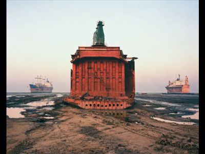 The carcass of a cargo ship, already sheared of its forward structure, sits where it was parked on the beach at Chittagong, Bangladesh