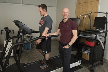 Steven Devor, front, developed the automated treadmill using off-the-shelf parts, including an inexpensive sonar range finder and an existing treadmill. (Photo by Jo McCulty, Courtesy of Ohio State University)