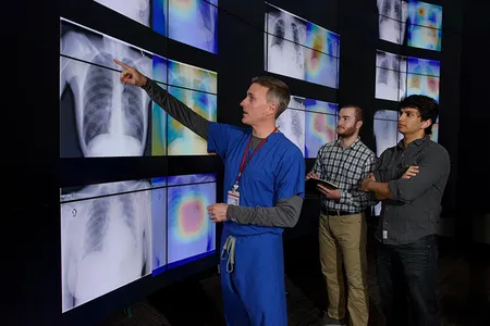 Stanford radiologist Matthew Lungren, left, meets with graduate students Jeremy Irvin and Pranav Rajpurkar to discuss the results of detections made by the algorithm.