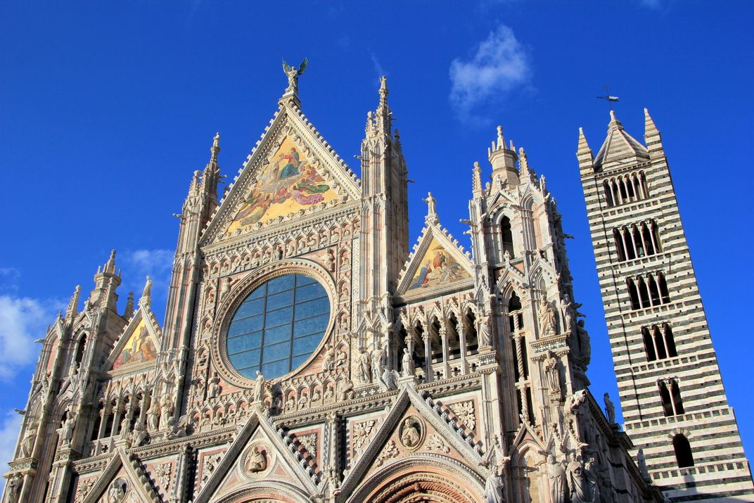 The facade and distinctive belltower of Siena's cathedral