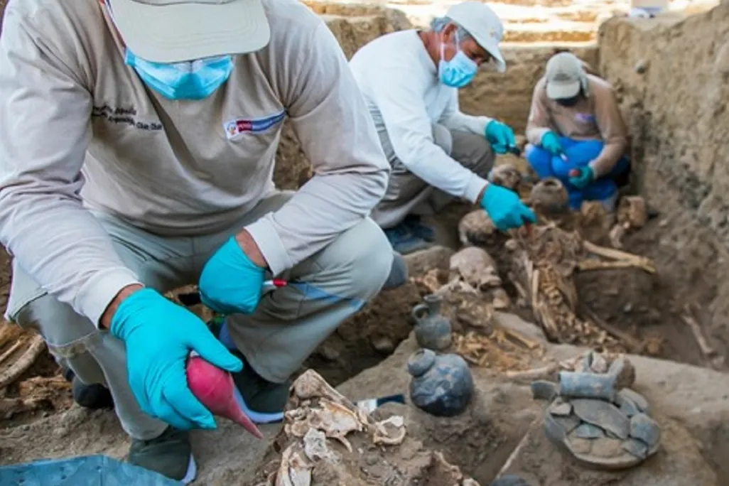 Workers excavate grave site