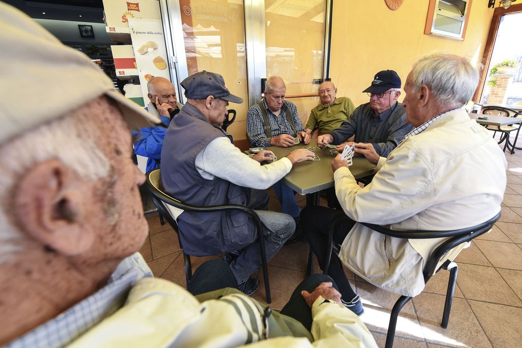 A group of old men playing cards in a bar