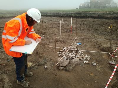 Archaeologists uncovered human remains and a mysterious arrangement of boulders at the site in the Shetland Islands.