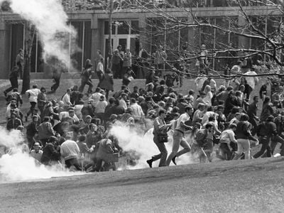 Anti-war demonstrators at Kent State University run as National Guardsmen fire tear gas and bullets into the crowd.