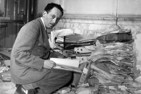 Louis de Jong, founder of Dutch Institute for War Documentation, examining documents on the Holocaust.

