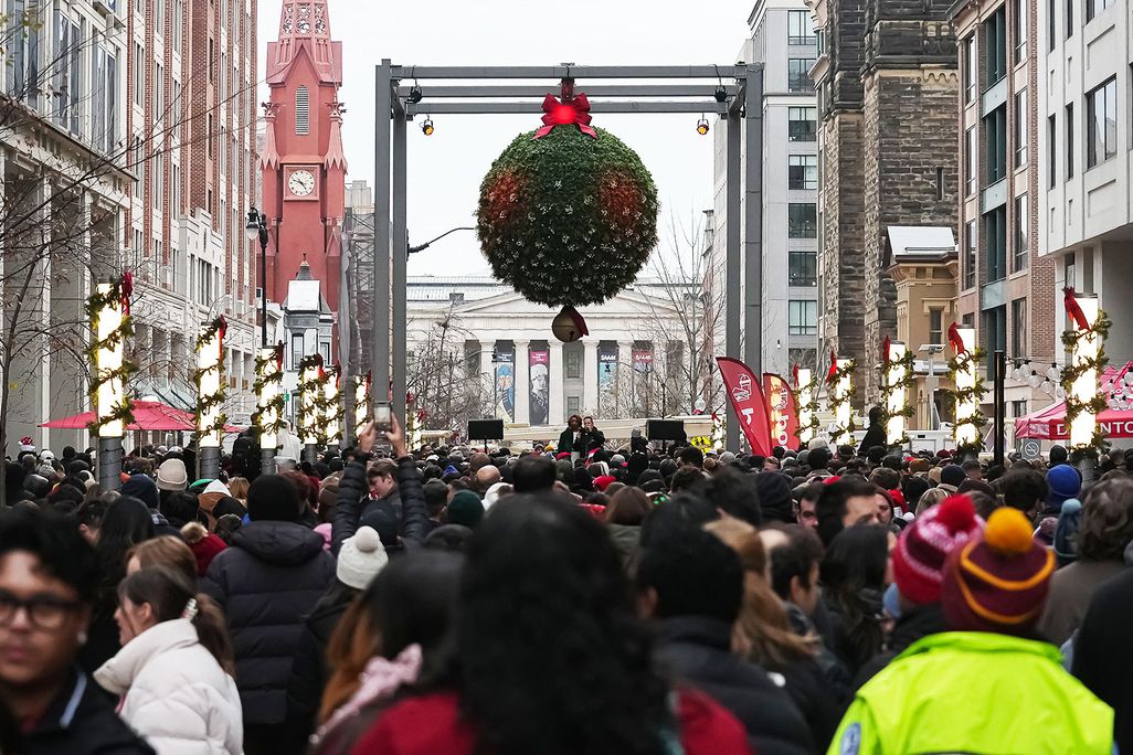 A crowd of couples kissing under mistletoe