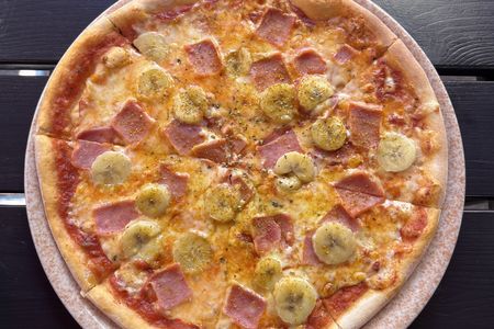 In Sweden, a popular pie is topped with bananas, cheese, curry and salty ham.
