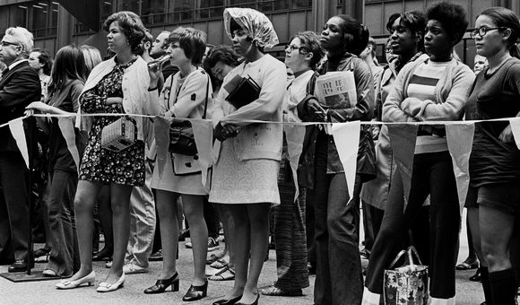 Women stand together behind a rope barrier at the Women’s March for Equality.