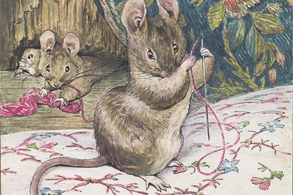 A brown mouse holds a needle and piece of pink thread and works on a delicate embroidery pattern of pink, blue and green flowers on white cloth, while two mice look on behind
