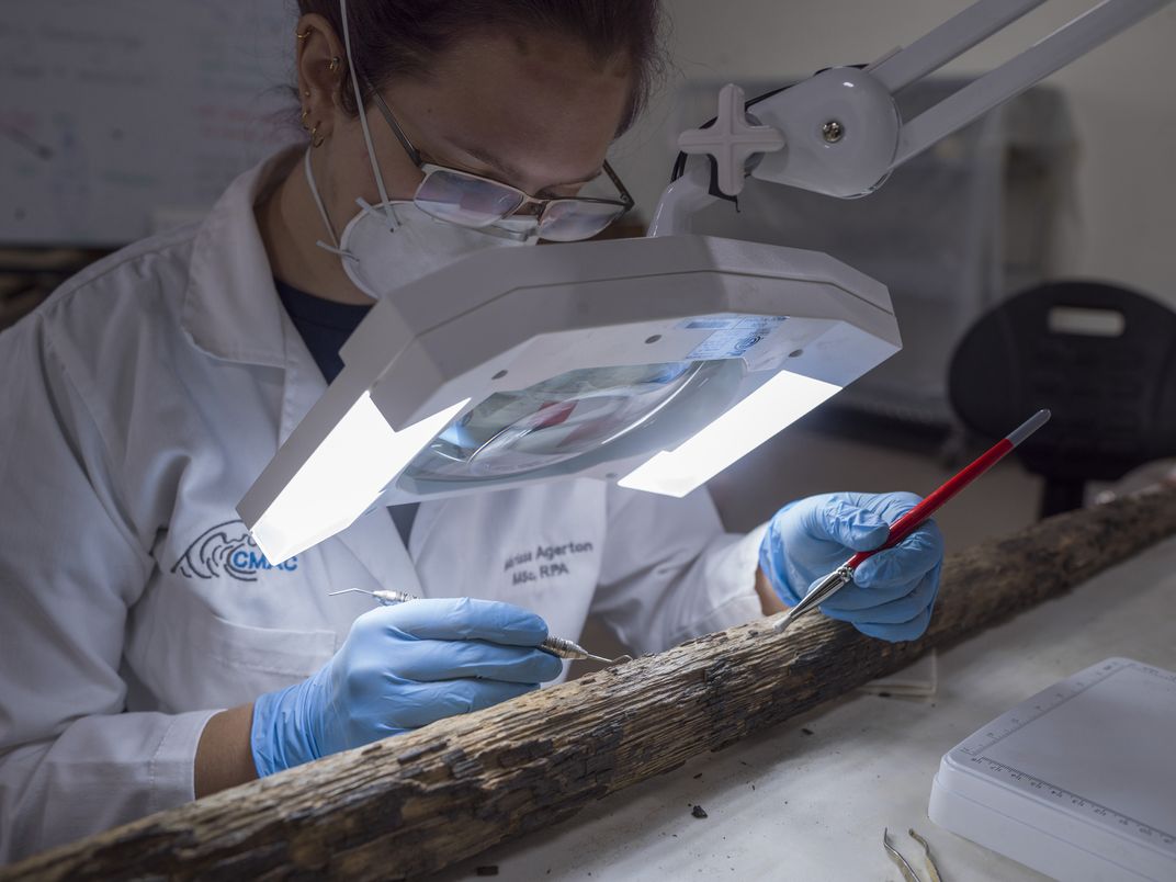 Marissa Agerton, a nautical archaeology specialist with Texas A&M, studies wood fibers from one of the vessel’s oars.
