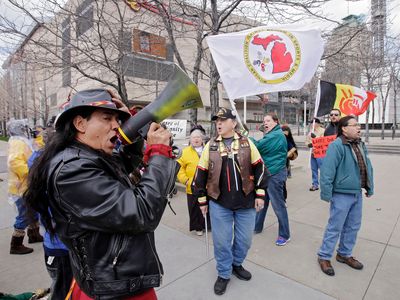 Philip Yenyo, executive director of the American Indian Movement for Ohio, leads a protest of the Cleveland Indians Chief Wahoo mascot before a baseball game against the Detroit Tigers Friday, April 10, 2015, in Cleveland.