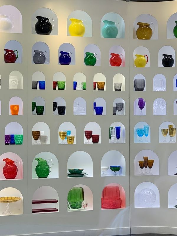 An exuberant display of colored glass vessels in cubbies in a shop window in Florence, Italy thumbnail