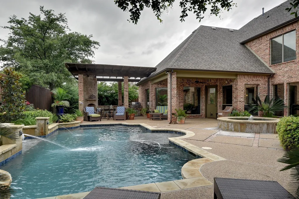 Swimming pool in backyard of brick house