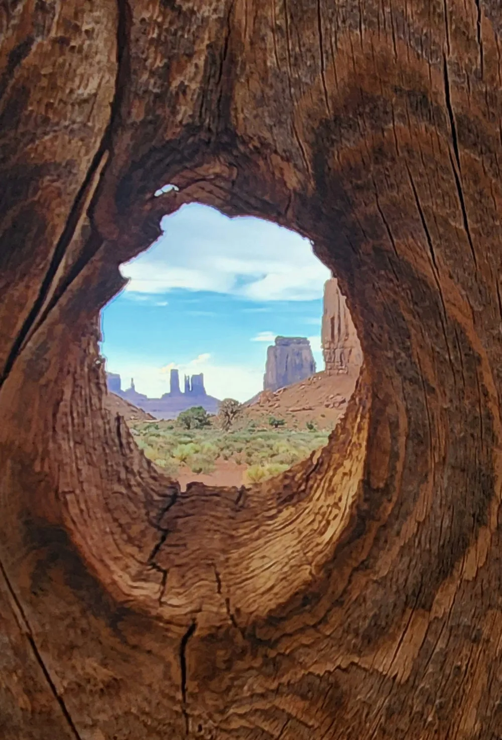 While visiting Monument Valley we stopped to look at the beautiful scenery a small structure on the side of the trail.  A knothole in the fence provided a unique frame for monuments in the distance.