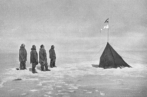 Roald Amundsen and his crew looking at the Norwegian flag at the South Pole, 1911