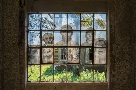This 2014 artwork by J.R. superimposes a historic photograph of immigrants on a broken window at the Ellis Island hospital.