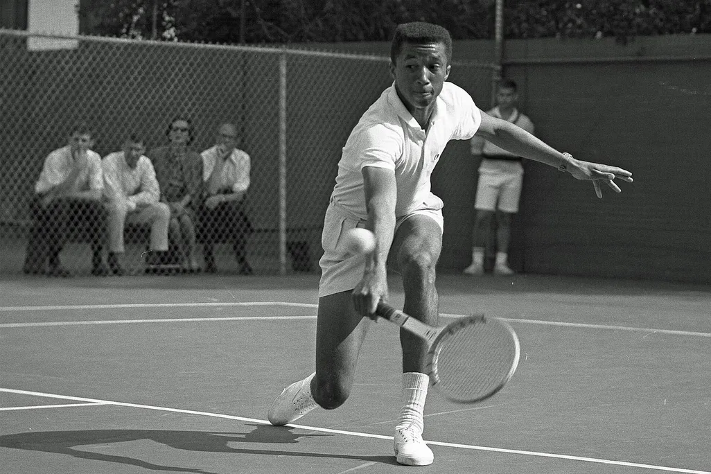 Arthur Ashe playing tennis against Dennis Ralston in 1964