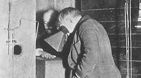 Thomas Edison examines Clarence Dally's, his assistant, hand thru a fluoroscope of his own design.