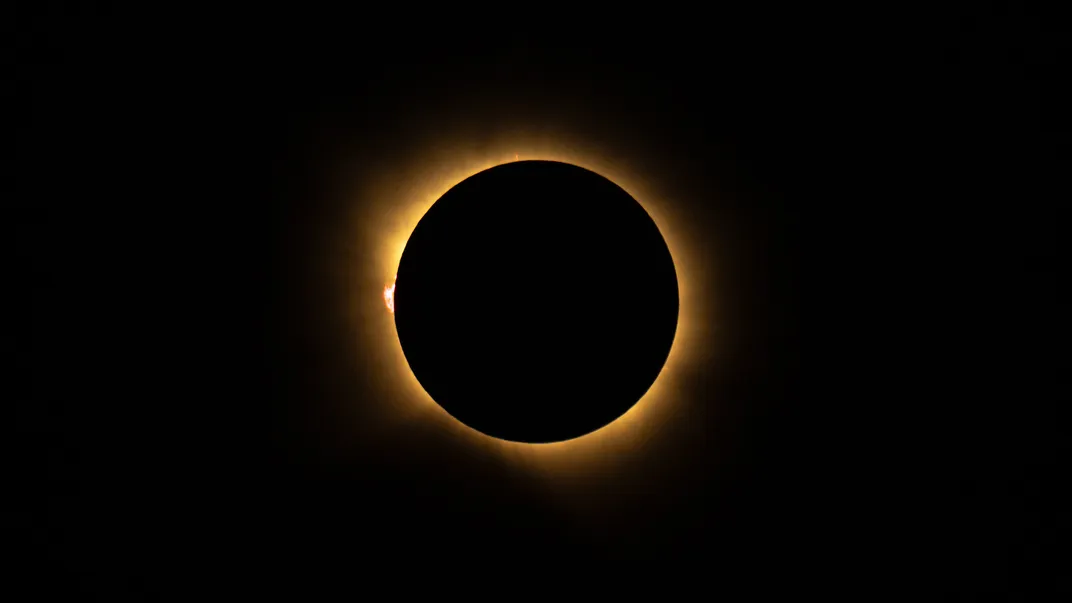 the eclipsed sun with a red bump at the left