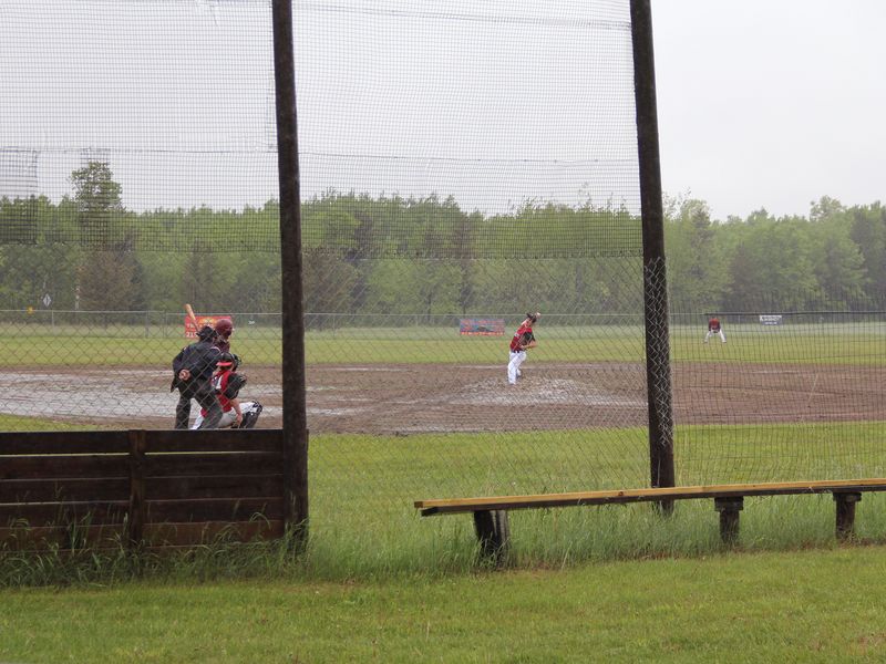 Playing ball in the rain at the country baseball field. The late, wet