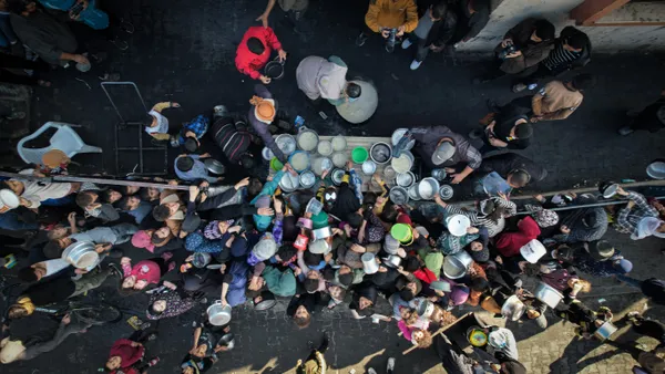 Children and people gather to earn food during the war in the Gaza Strip thumbnail