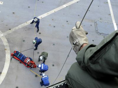 090920-N-7478G-286
PACIFIC OCEAN (Sept. 20, 2009) A naval air crewman, assigned to the Warlords of Light Helicopter Antisubmarine Squadron (HSL) 51, holds a rescue line as hospital corpsman from amphibious command ship USS Blue Ridge (LCC 19) train for medical evacuations underway. (U.S. Navy photo by Mass Communication Specialist 2nd Class Cynthia Griggs/Released)