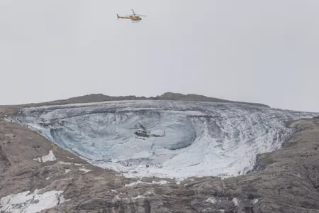Helicopters fly above the collapsed section of the Marmolada glacier in Italy.

