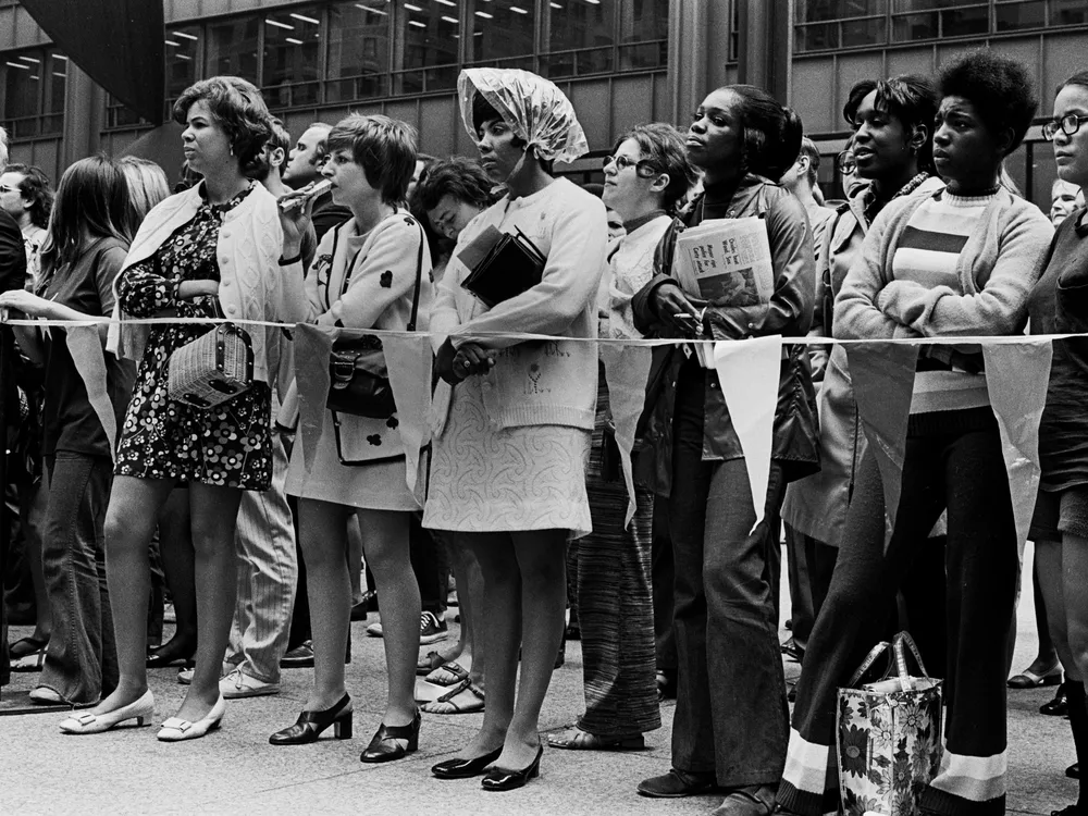 Women stand together behind a rope barrier at the Women’s March for Equality.