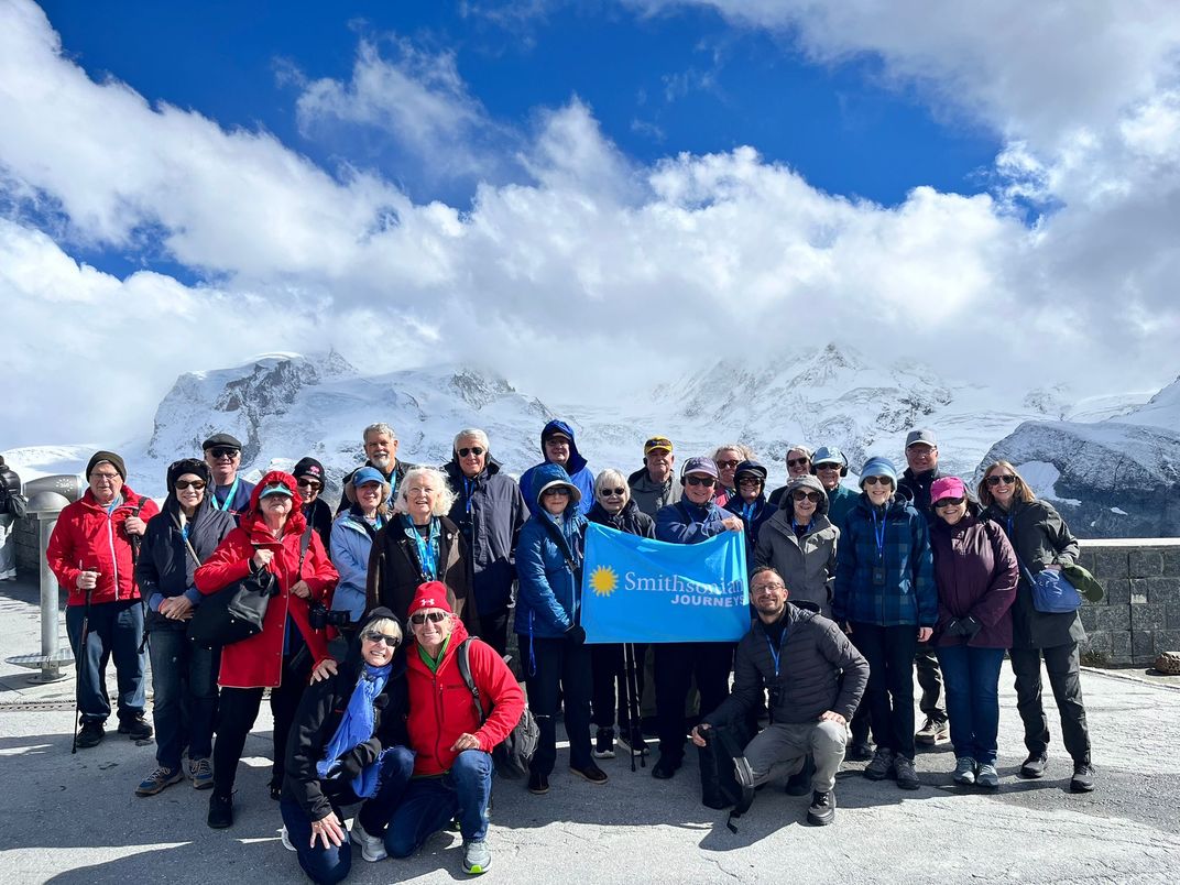 Smithsonian Journeys Travelers with The Matterhorn just out of view behind the clouds.