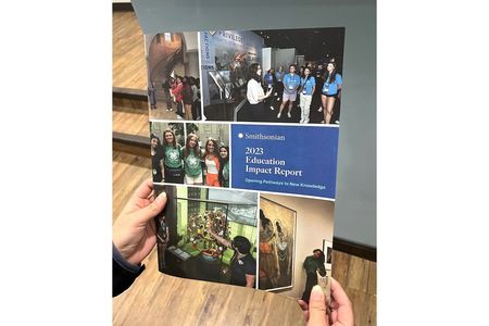 Hard-copy of the FY2023 Smithsonian Education Impact Report held in someone’s hands.