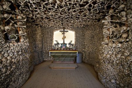 From the road, it would be easy to overlook this small, unassuming chapel located in one of the oldest towns in southwestern Poland. But the wooden doors hide a spectacular, macabre interior. The skulls and leg bones of over 3,000 victims of wars and plagues cover the walls and ceiling, and a crypt below, accessible through a trapdoor, houses over 21,000 additional remains. Between 1776 and 1804, the local priest, Vaclav Tomasek, painstakingly gathered, cleaned and carefully arranged skeletons recovered from numerous, shallow mass graves left by the Thirty Years’ War, Silesian Wars and cholera outbreaks. Modeled off of similar ossuaries and catacombs in Rome, the chapel was intended as a shrine for the dead, as well as a “memento mori” for the living. 

On the church’s altar, Tomasek placed the bones of important figures and curiosities, including the skull of the local mayor, skulls with bullet holes, a skull deformed by syphilis and the bones of a supposed giant. When the chapel's creator passed away in 1804, his skull was placed on the altar as well.

View the photos above or explore the 360° interactive panorama on  Kaplica Czaszek’s official site  (in Polish).