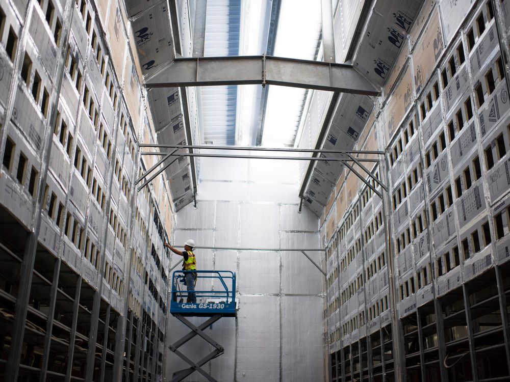 A worker on a lift in a bitcoin mining facility