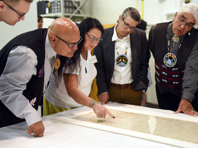 Members of a delegation from the Pokagon Band of Potawatomi Indians read names of the signers of the Treaty of Fort Wayne of 1809 as the museum prepares to place the treaty on exhibit. From left: Tribal Council Member Wayne (Alex) Wesaw, Council Chairman John P. Warren, Council Elders Representative Judy Winchester, Tribal Historic Preservation Officer; Jason S. Wesaw, and Council Vice Chairman Robert (Bob) Moody, Jr. National Museum of the American Indian, Washington, D.C., September 2017. (Kevin Wolf/AP Images for National Museum of the American Indian)