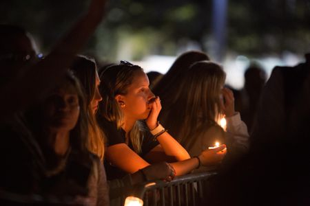 People attend a vigil for the victims of the shooting at Marjory Stoneman Douglas High School, in Pine Trails Park in Parkland, Florida on February 15, 2018.