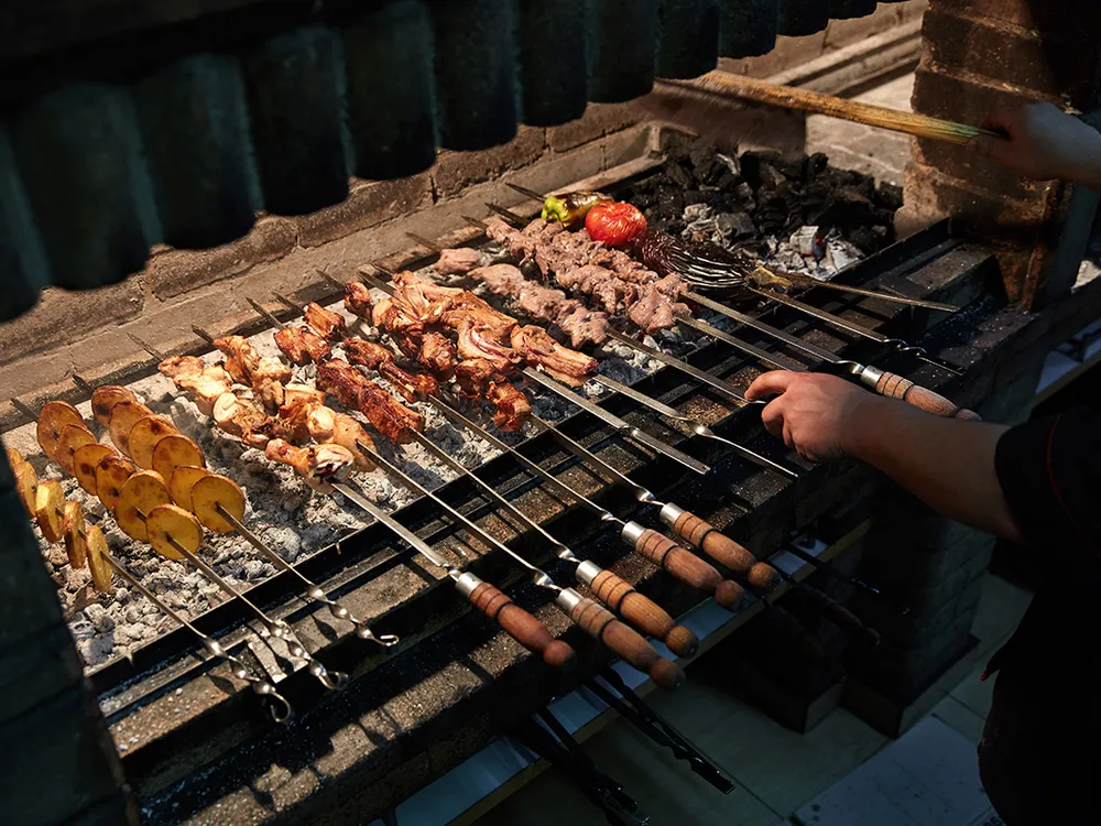 A cook works on khorovats skewers at Taron Restaurant in Yerevan.