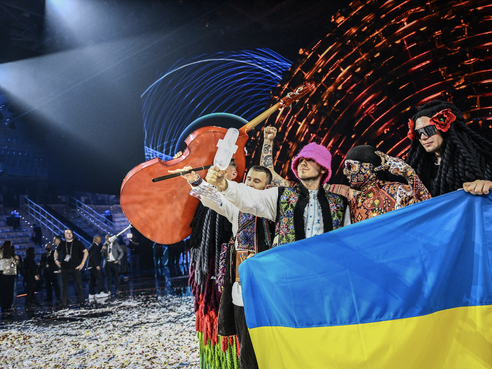 Members of the band Kalush Orchestra pose onstage with the winner's trophy and Ukraine's flags after the Eurovision Song Contest on May 14, 2022.