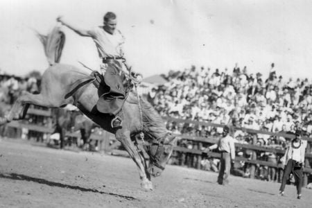 A convict hangs on to a bucking bronco c. 1940