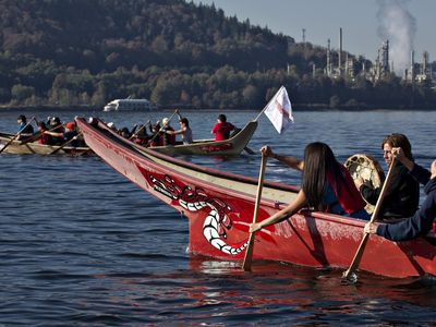 Members of the First Nation Tsleil-Waututh, Squamish and Musqueam bands paddle in traditional canoes during a Thanksgiving protest in North Vancouver, British Columbia October 14, 2013. The group are protesting the Trans Mountain Pipeline Expansion by energy company Kinder-Morgan and the increase of tanker traffic in the Burrard Inlet. 
