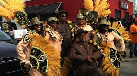 Members of a New Orleans social aid and pleasure club sport stylish and costly outfits and masquerade regalia. Organizations like these walk together in funerals and parades, such as the famous New Orleans Mardi Gras parade.
