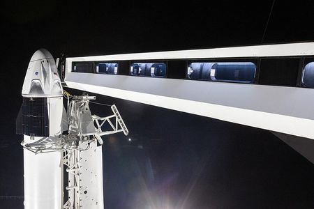 A new access arm for astronauts connects to the Crew Dragon vehicle atop a SpaceX Falcon 9 rocket at Cape Canaveral's storied Pad 39-A.