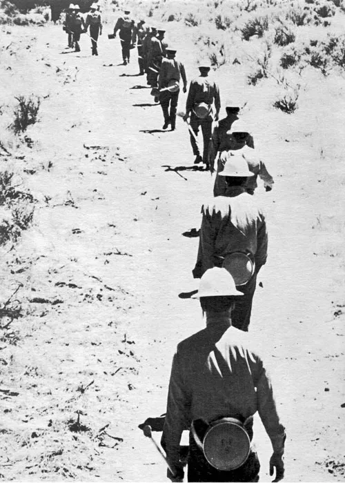 Prisoners marching toward a fire, circa 1961