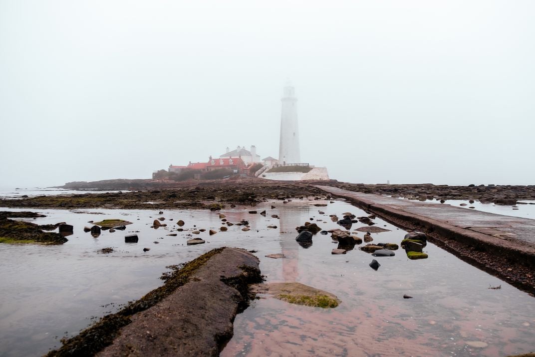 14 - Shallow water and heavy fog surround the 125-year-old St. Mary’s Lighthouse in Whitley Bay.