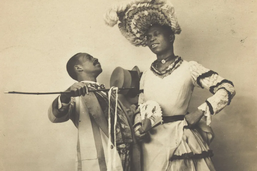 1903 postcard of two Black actors, one of whom is dressed in drag, performing a cakewalk in Paris