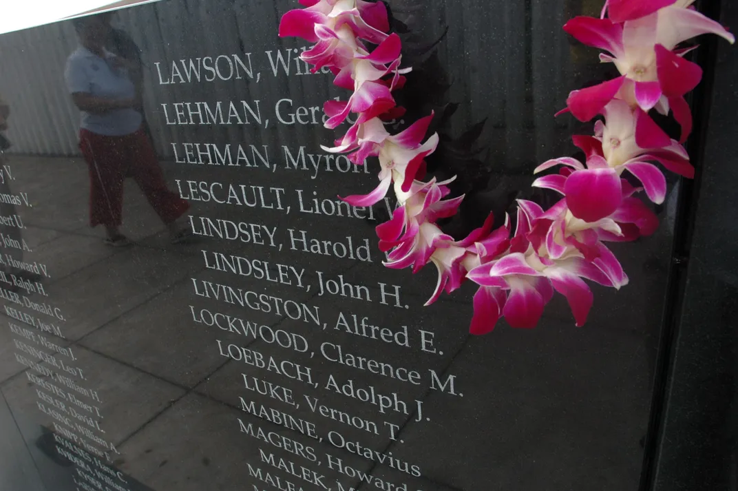 Orchid lei draped over memorial bearing the names of U.S.S. Oklahoma victims