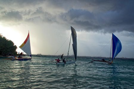 Outrigger canoes race in the Majuro lagoon in the Marshall Islands. Traditional Marshallese wave piloting uses the feeling of the ocean to navigate precisely across vast stretches of open water.