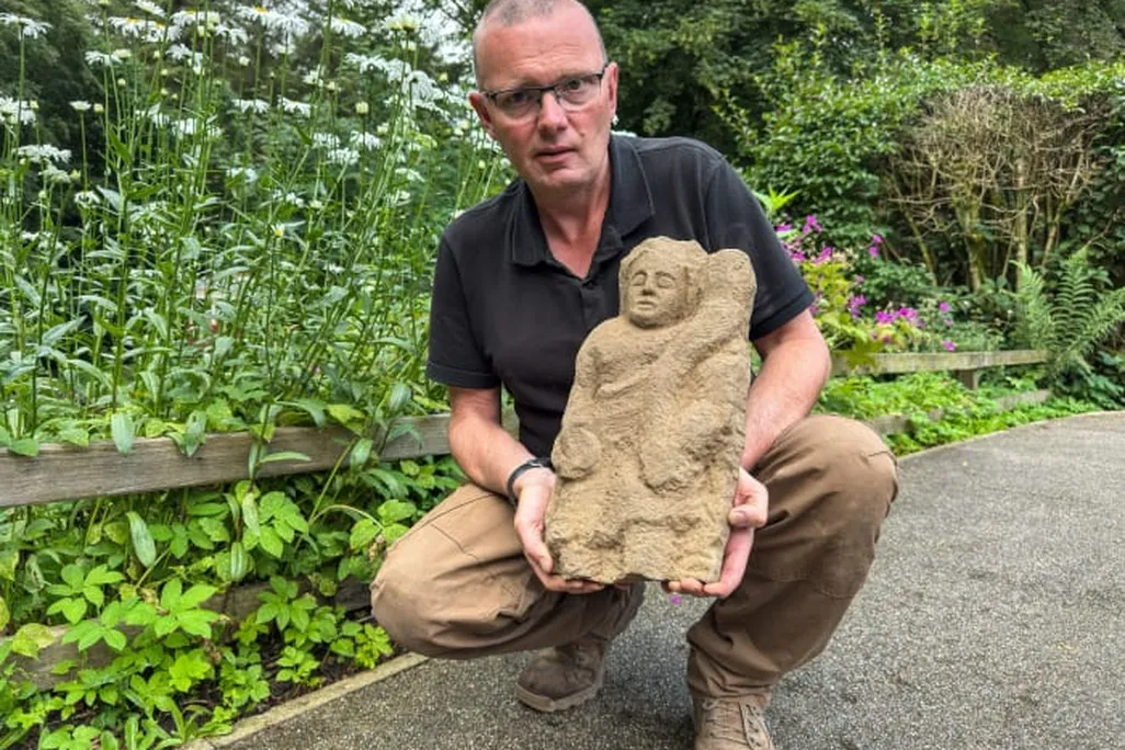 A man holding a figurine of a person